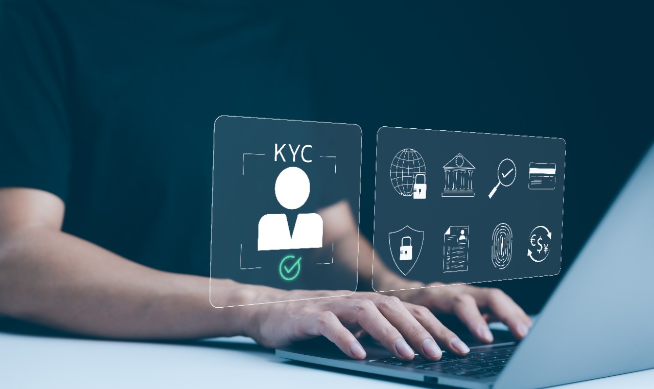 Know Your Customer (KYC) Concept. A person works on a laptop, displaying digital icons representing Know Your Customer (KYC) processes, including security, identification, and financial compliance.